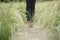 Blurred Background grass on the side road and walking women jeans and sneaker shoes