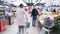 Blurred background of a grocery hypermarket, people walk in masks coronavirus