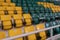 Blurred background. Looking visually impaired person. Yellow and green plastic seats in the stands of the sports complex.