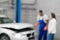 Blurred background of Mechanic and client inspect engine of car.