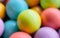 Blurred background from multicolored bright small wooden balls of blue, yellow, red, lilac and green colors