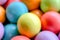 Blurred background from multicolored bright small wooden balls of blue, yellow, red, lilac and green colors