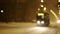 Blurred background, out of focus. The tram travels along the night street on a snowy evening.