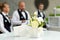 Blurred background, professional waiters standing in a row. Outdoor party with finger food. Catering service.