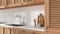 Blurred background, provencal wooden kitchen, close up. Cabinets with shutters and rattan drawers, leather handles, sink, pottery
