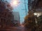 Blurred background of raindrops seen through car windows overlooking roads, buildings, houses and orange light pillars at dusk