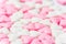 Blurred background for Valentines day charity romantic concept from white and pink sugar candy hearts. Girls baby shower birthday