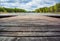 Blurred background with wooden pier on the shore of a large lake in the forest. Wonderful spring landscape. A cozy place for rest,