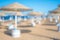 Blurred blue sea and white sand beach with parasol, beach chair. blurred beach umbrella background. Holiday, vacation and