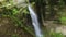 Blurred or bokeh effect on waterfall background. Stone cliff and falling stream in background in blur.