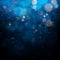 Blurred bokeh light on dark blue background. Christmas and New Year holidays template. Abstract glitter defocused