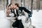 Blurred bride and groom are kissing on background of syberian husky. Winter wedding. Artwork