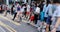 Blurred Busy crowds of men and women or Commuters Crossing Street in Central, Hong Kong, with Crosswalk yellow lines. zebra yellow