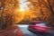 Blurred car going mountain road in autumn forest at sunset