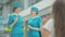 Blurred Caucasian little girl waving to beautiful stewardesses in blue uniform. Two confident slim women talking in