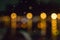 Blurred city lights with rain drops foreground. Unfocused colorful lights behind glass with drops. Shiny lights of night bokeh.
