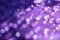 Blurred decorated violet colored backdrop with copy space. White round glowing sparkles