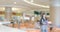 Blurred defocused background of public food court hall showing eating and walking people, business commercial area