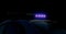 Blurred defocused silhouette of road police patrol car on the street of city at night. Flashing blue police car led lights in