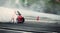 Blurred of diffusion race drift car with lots of smoke from burning tires on speed track