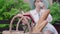 Blurred elegant woman reading book at the background, basket with baguettes and wine standing in front. Literature