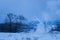 Blurred evening background explosion of a combat projectile over a snow covered field