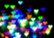 Blurred festive background with defocused colourful glitter formed a heart, bokeh in a shape of a heart. Original photographic