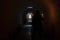 The blurred figure of a man in a hood, holding a burning candle underground corridor