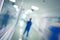 Blurred figure of medical doctor walking in the long hospital corridor, defocused background