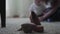 Blurred figure of unrecognizable mother playing with her baby son sitting on the floor in the background. Women`s