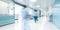 Blurred figures of healthcare workers in motion through the corridor of a modern clinic - a testament to cohesive