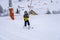 Blurred focus background. A boy lifting on the ski drag lift rope in bright sport outfit on the ski resort mountain do a