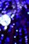 Blurred fragment of the New Year tree. Lots of round lights in blue