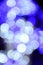 Blurred fragment of the New Year tree. Lots of round lights in blue