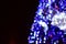 Blurred fragment of the New Year tree. Lots of round lights in blue