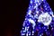 Blurred fragment of the New Year tree. Lots of round lights in blue