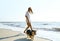 Blurred full length image joyful girl in white shirt at summer sea beach with her pet Corgi dog