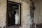 A blurred, ghostly figure. Framed in a window in a decaying old abandoned house