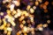 Blurred golden lights abstract background in the night, defocused dark glowing bokeh backdrop, magical yellow illuminated sparkle