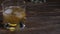Blurred. Golden malt whiskey poured into a glass glass with ice cubes