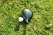 Blurred golf club and golf ball close up in grass field with sunset.