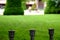 Blurred green lawn background. brass railing posts detail in closeup