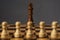 Blurred group of pawns before king on chess board, concept of ordinary people before or against power or authority