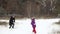 Blurred image of a family of four: mom, dad, son and daughter are playing snowballs in nature.