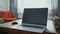 Blurred image of home workspace with laptop and wooden table