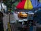 Blurred image, Kolkata, West Bengal, India. A roadside shop is being wet under monsoon raining, waterlogged road in the