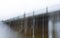 Blurred image of a long ancient bridge with a wrought-iron fence in the fog, made with a long exposure. The concept of a long hard