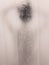Blurred image of unrecognizable silhouette of girl back view taking shower in the shower bath