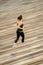 Blurred image of Woman jogging on rows of  wood venue seating