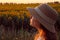 Blurred image of a young girl wearing a hat and looking to the side, beautiful sky bakground.